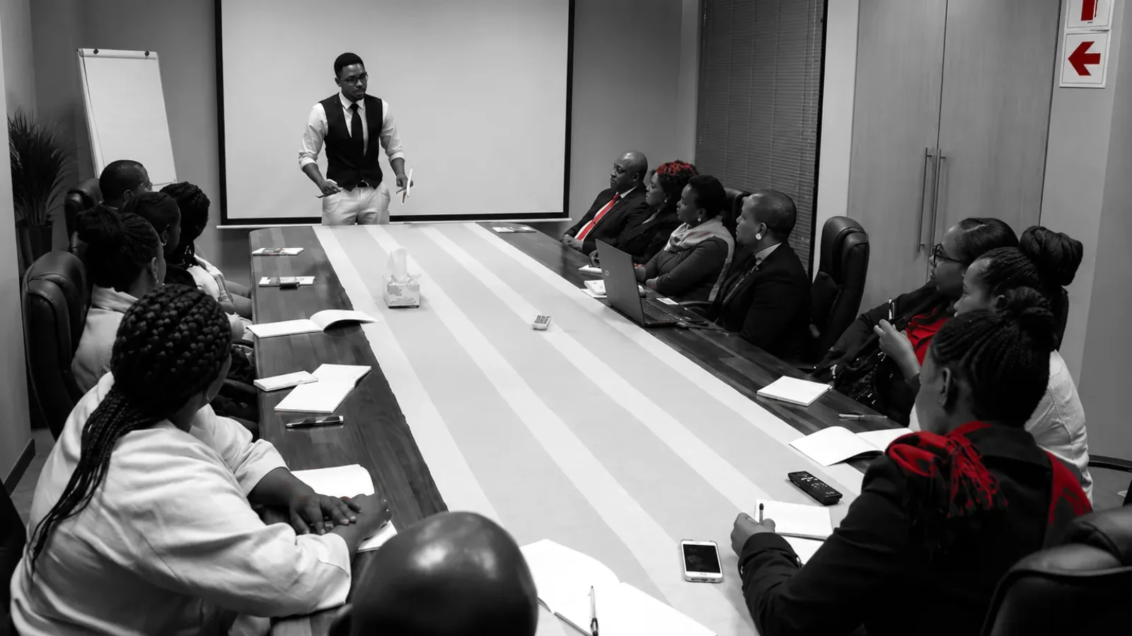 Omar Stone presenting to business leaders seated around a boardroom table